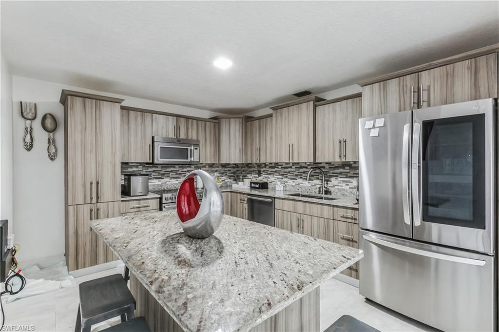 a kitchen with stainless steel appliances granite countertop a refrigerator sink and stove