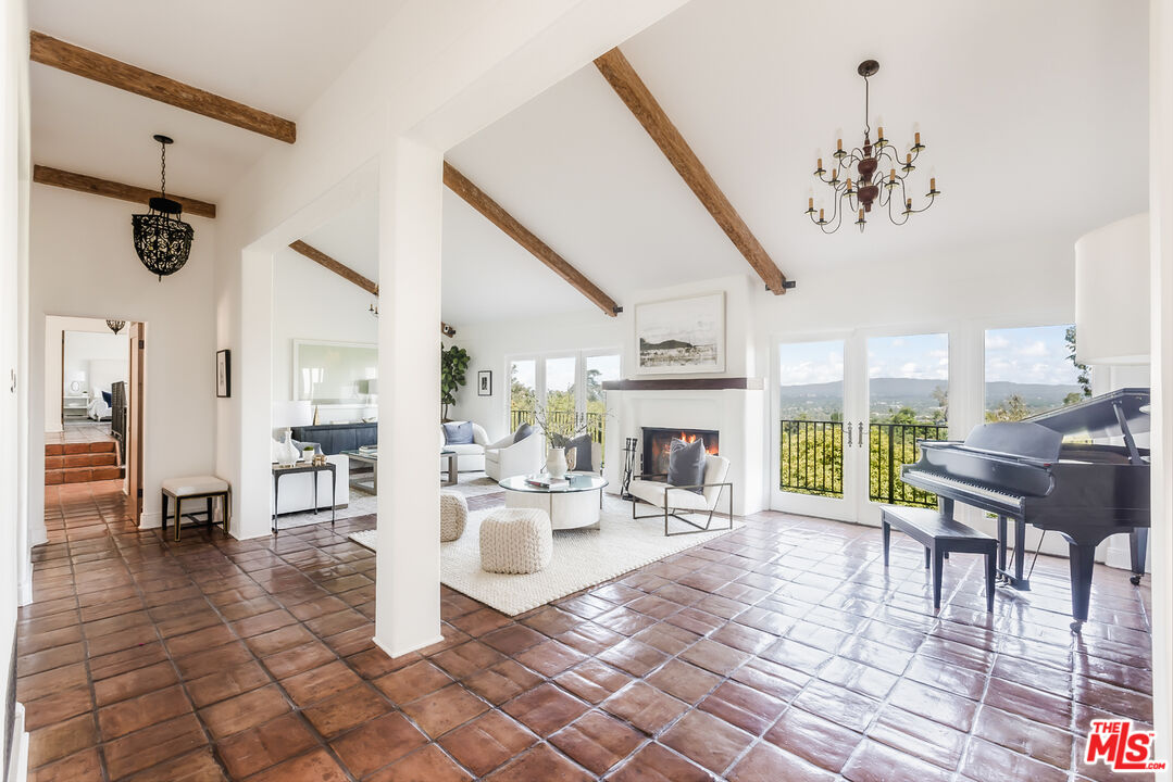 a living room with furniture a dining table and a chandelier