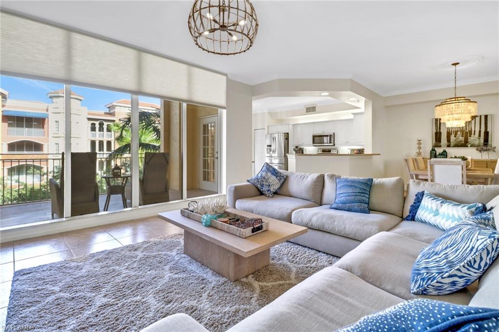 a living room with furniture a chandelier and a table