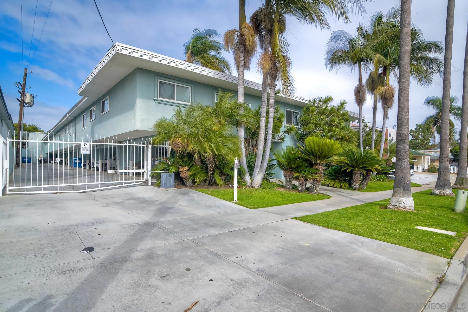 a view of a house with a yard and palm trees