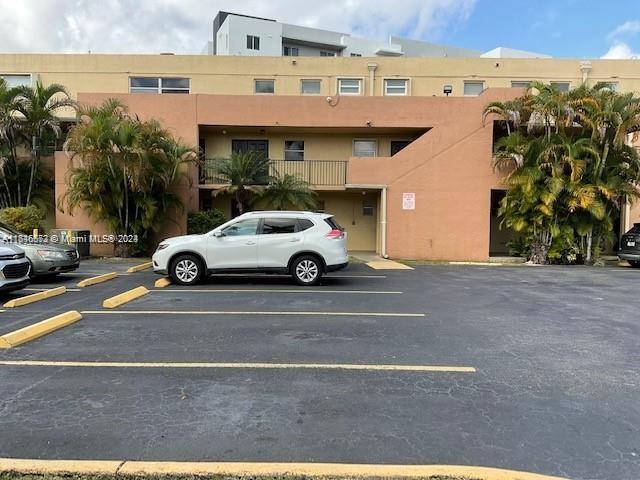 a view of parking area and car parked in front of it