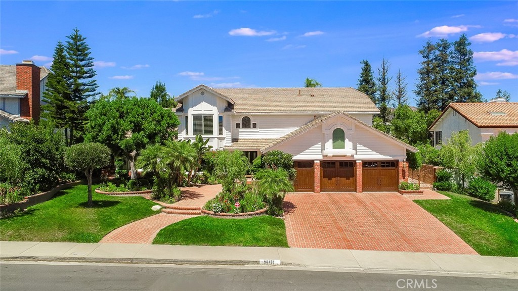 a front view of a house with a yard and potted plants