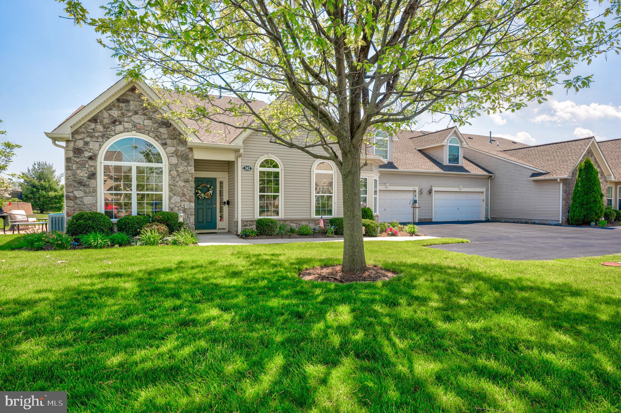 a front view of a house with a yard and trees