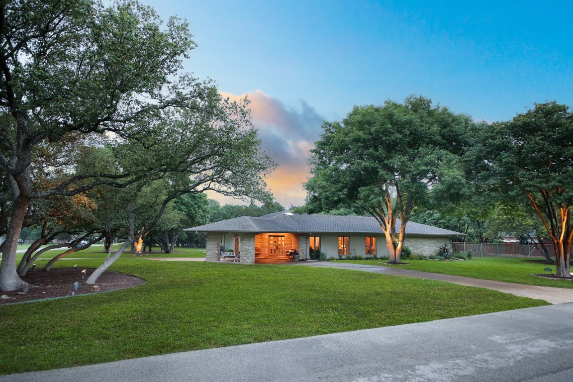 a front view of a house with a yard and trees