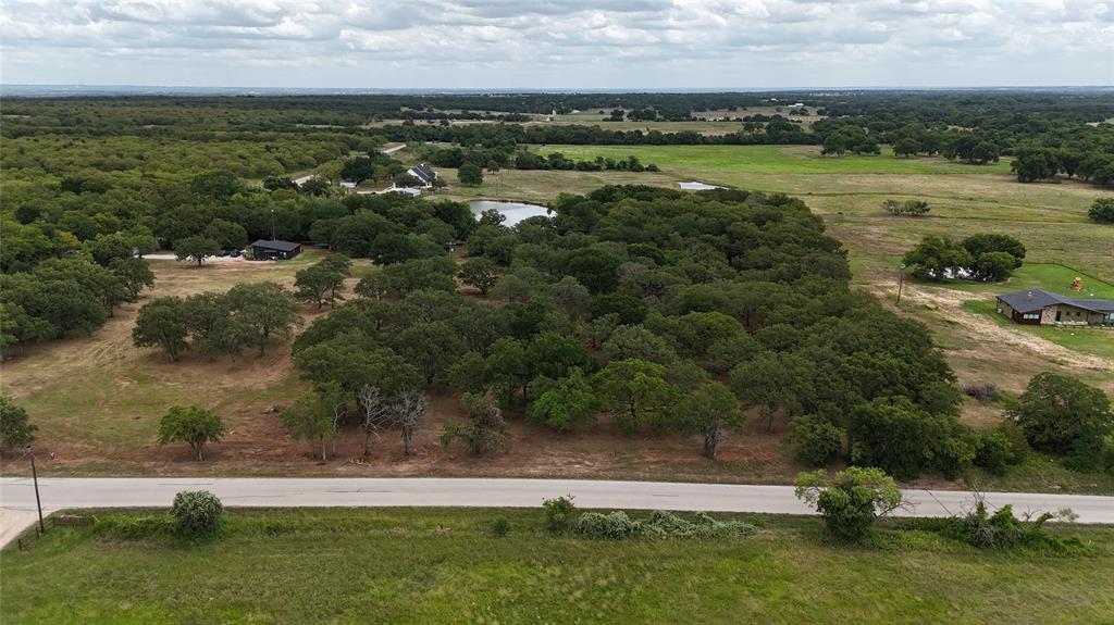 an aerial view of field with trees