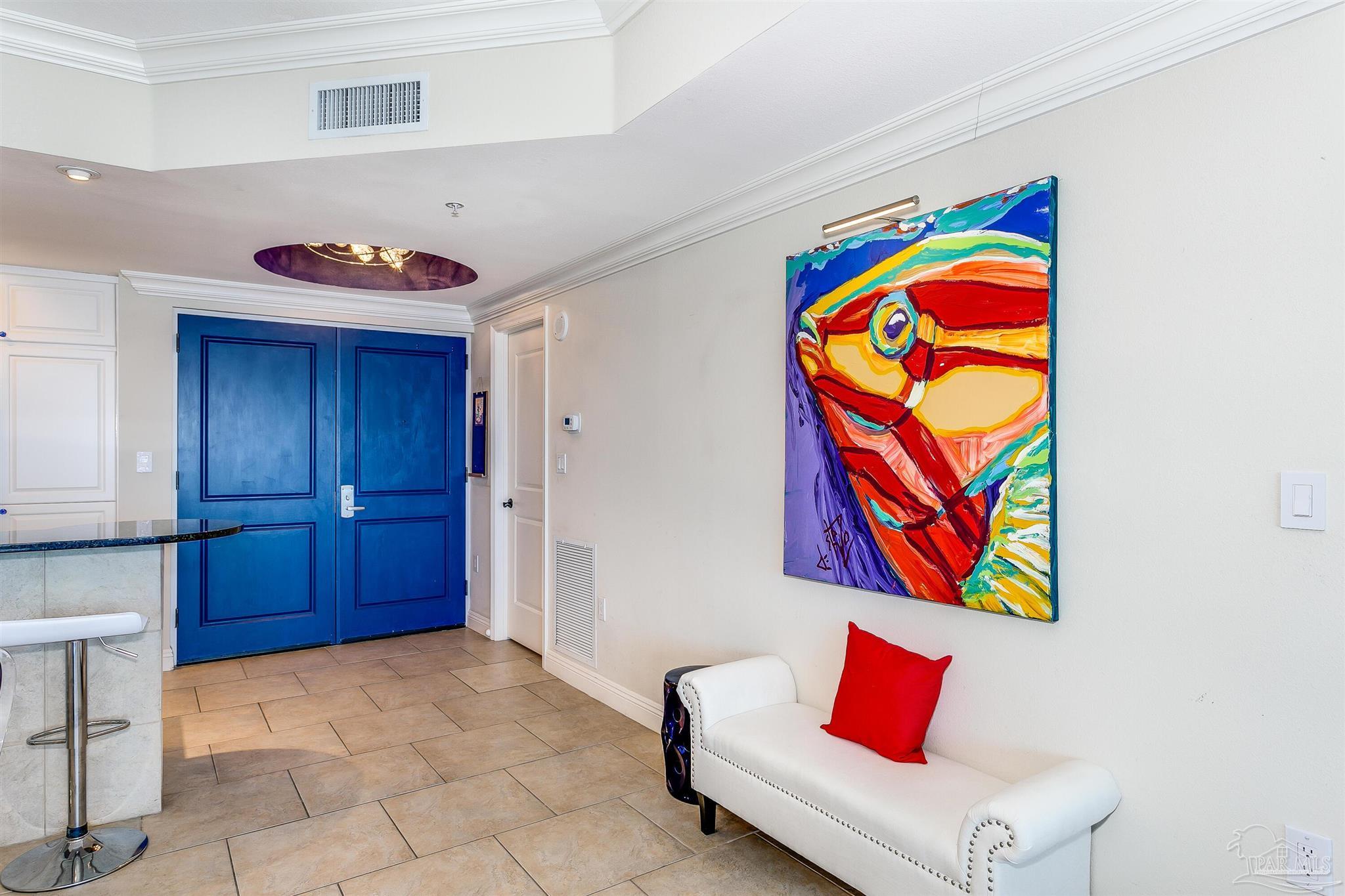 a living room with painting on the wall and a potted plant