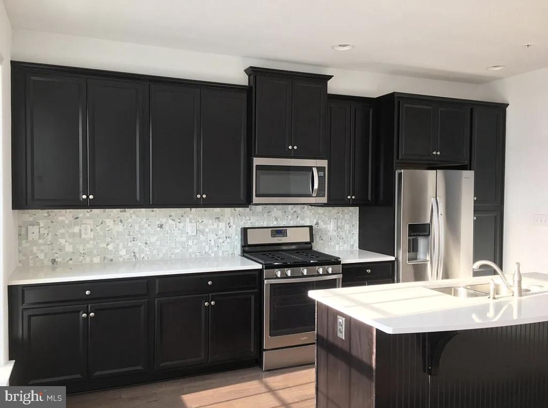 a kitchen with a sink stove and microwave