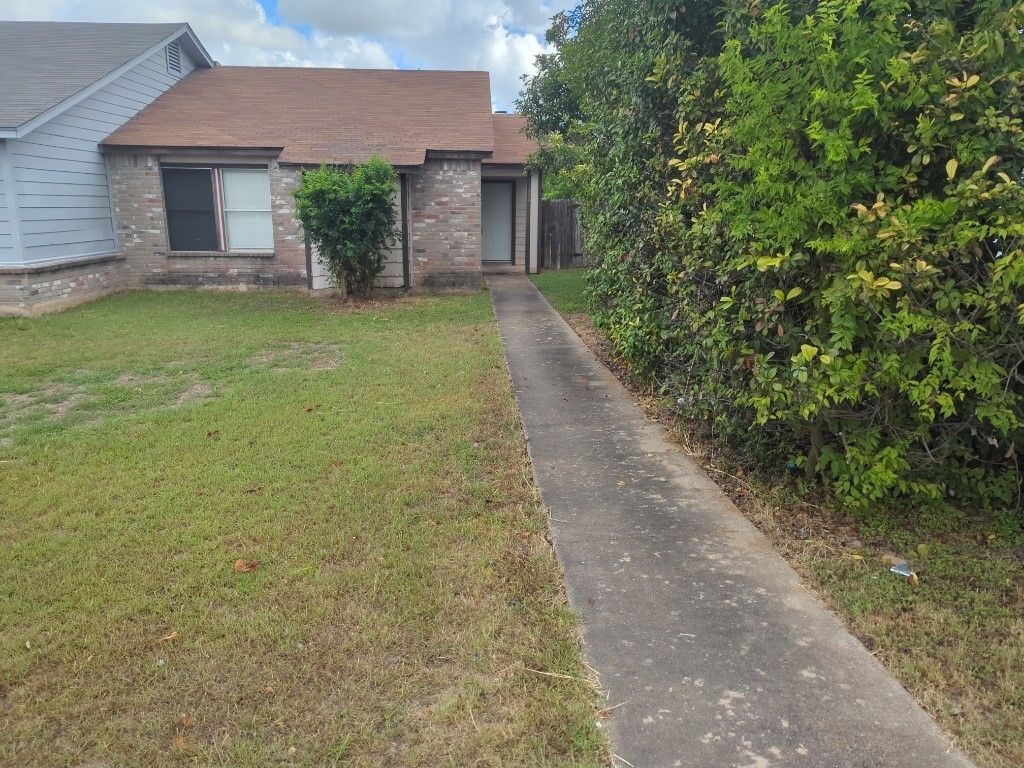 a front view of a house with a garden and yard