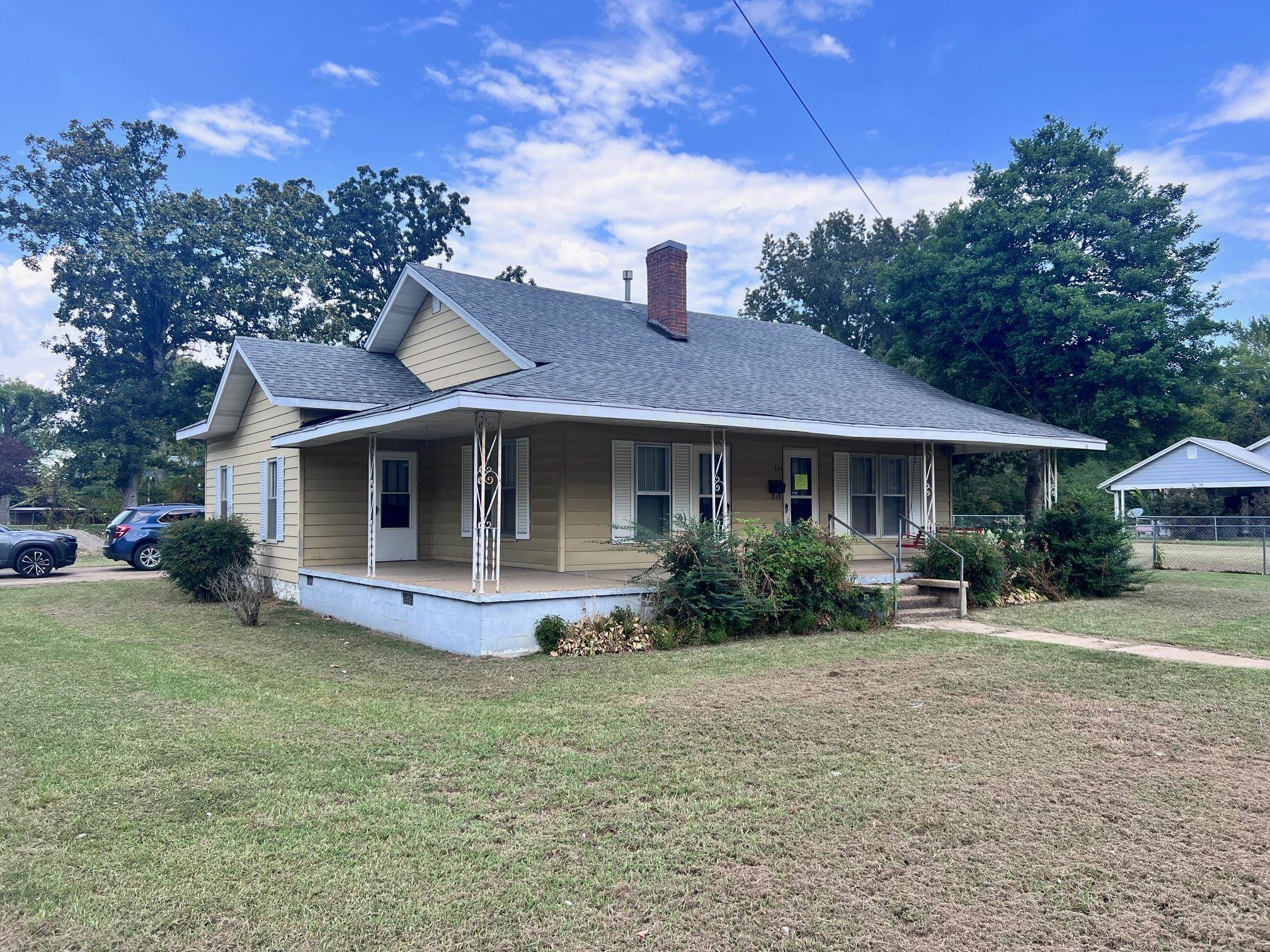 a front view of a house with a yard and trees