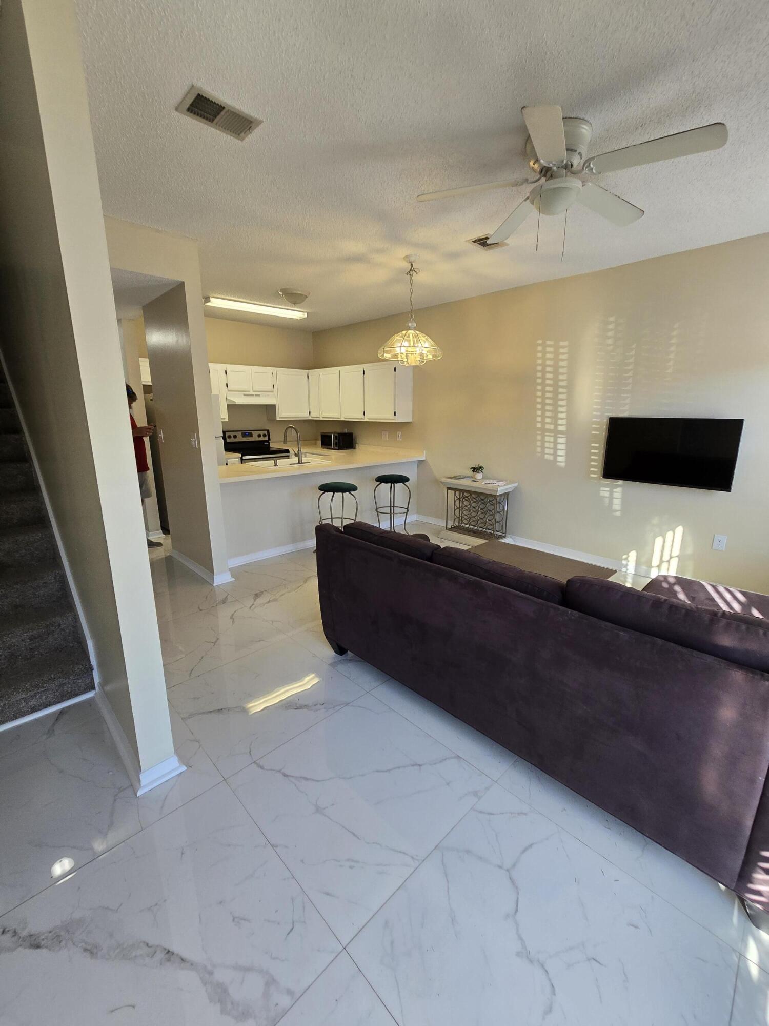 a living room with stainless steel appliances kitchen island granite countertop furniture and a view of living room