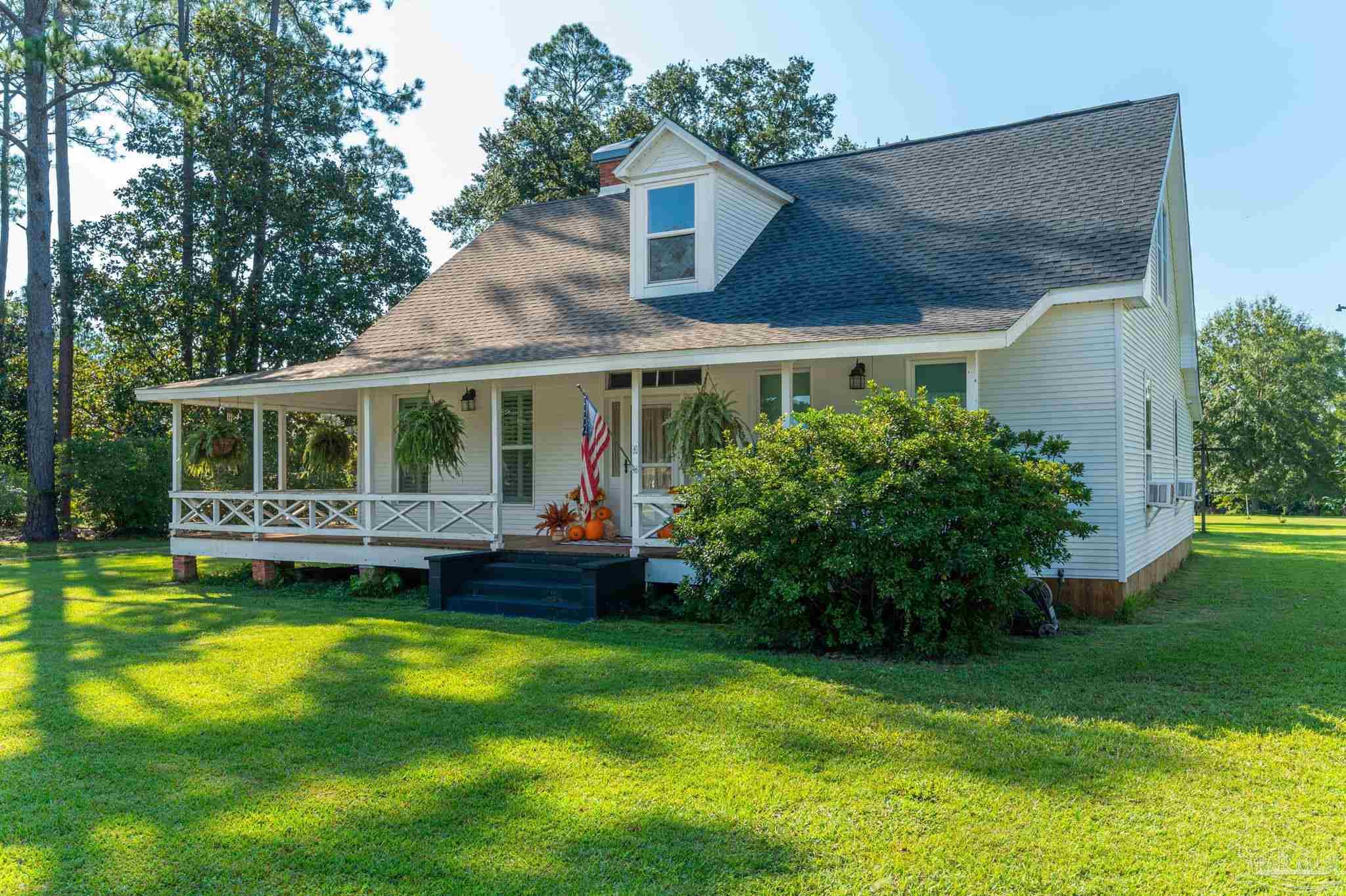 a view of house with garden and swimming pool