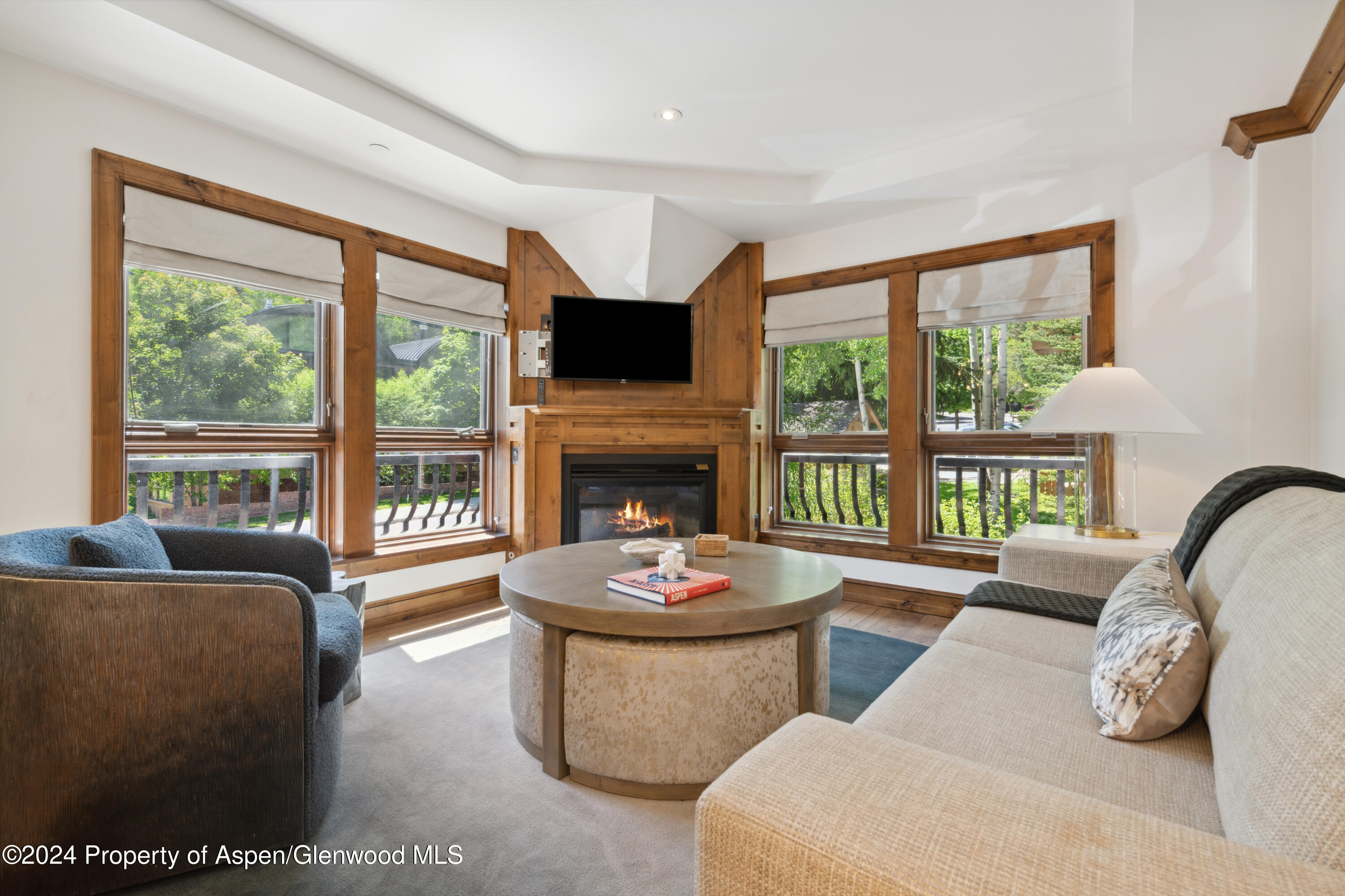 a living room with couches a coffee table and a large window with outer view