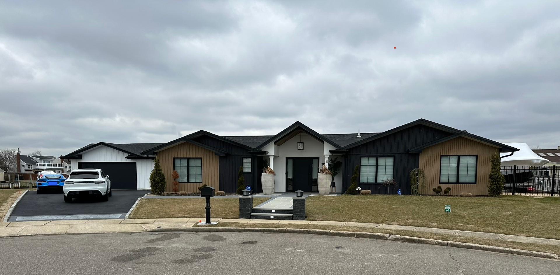 Single story home with a garage and a front lawn