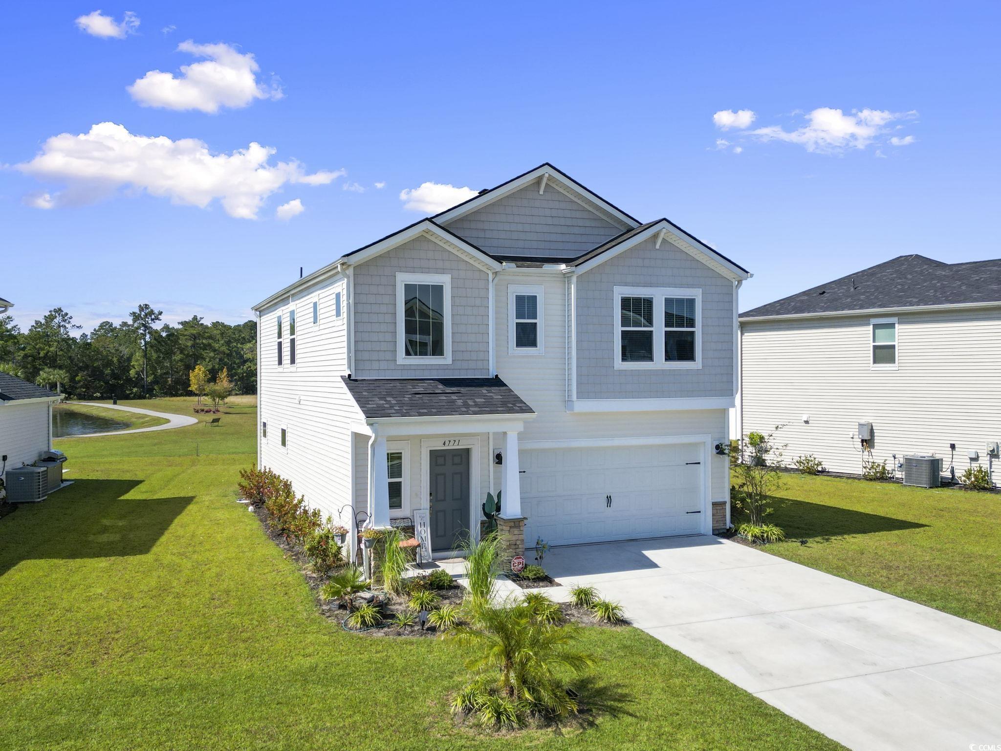 View of front facade with a front yard, a garage,