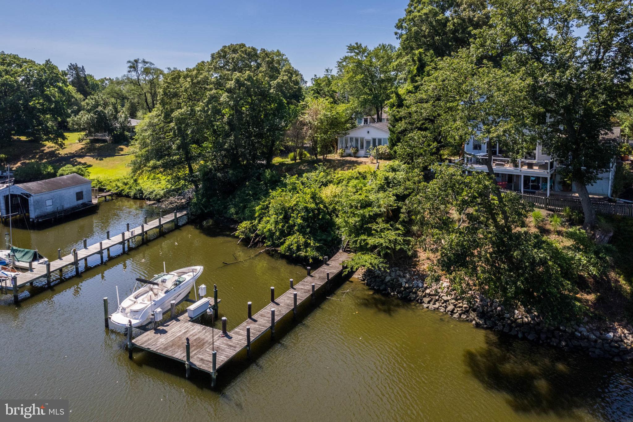 an aerial view of water body with boats and trees all around