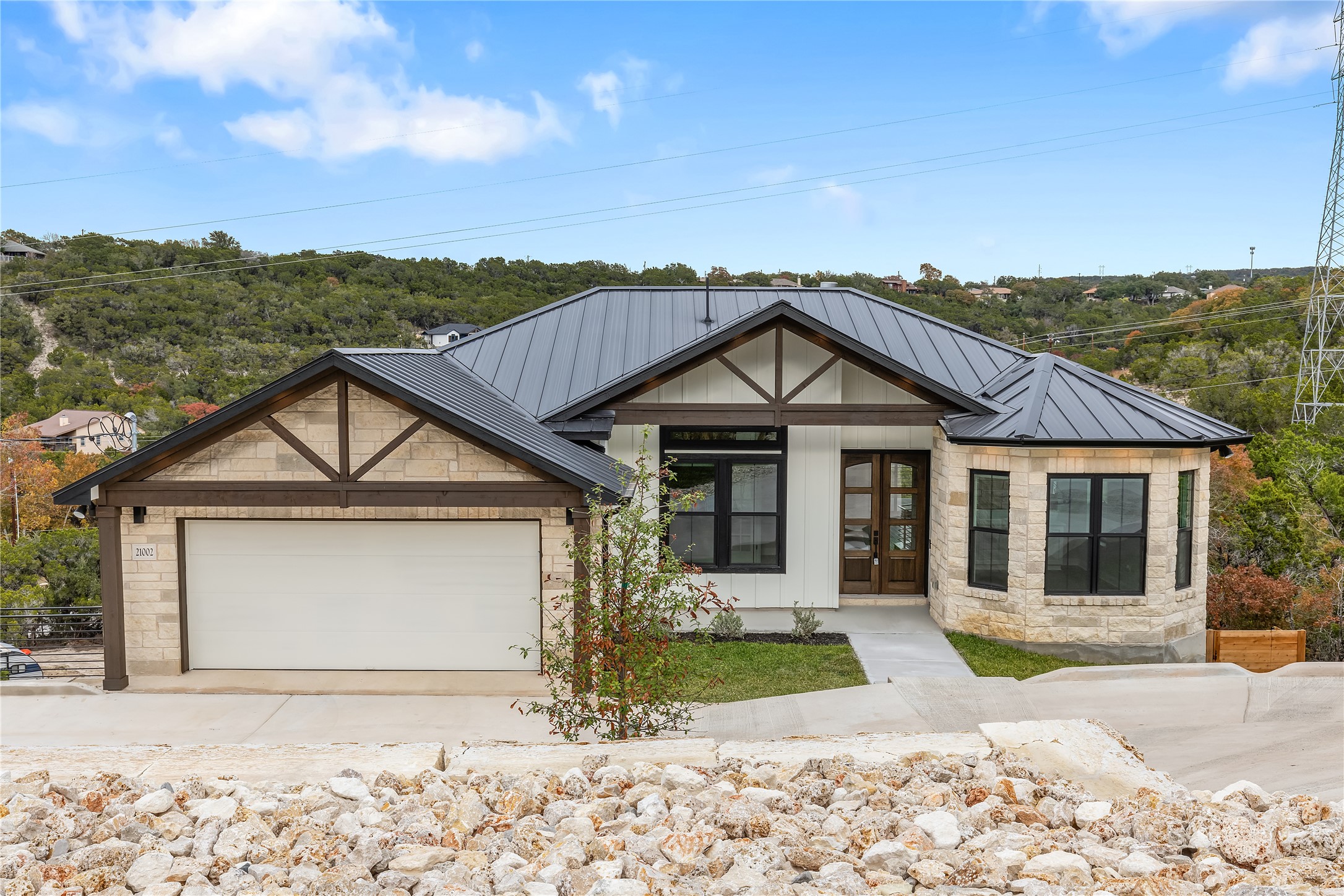 a front view of a house with a yard and mountain view in back