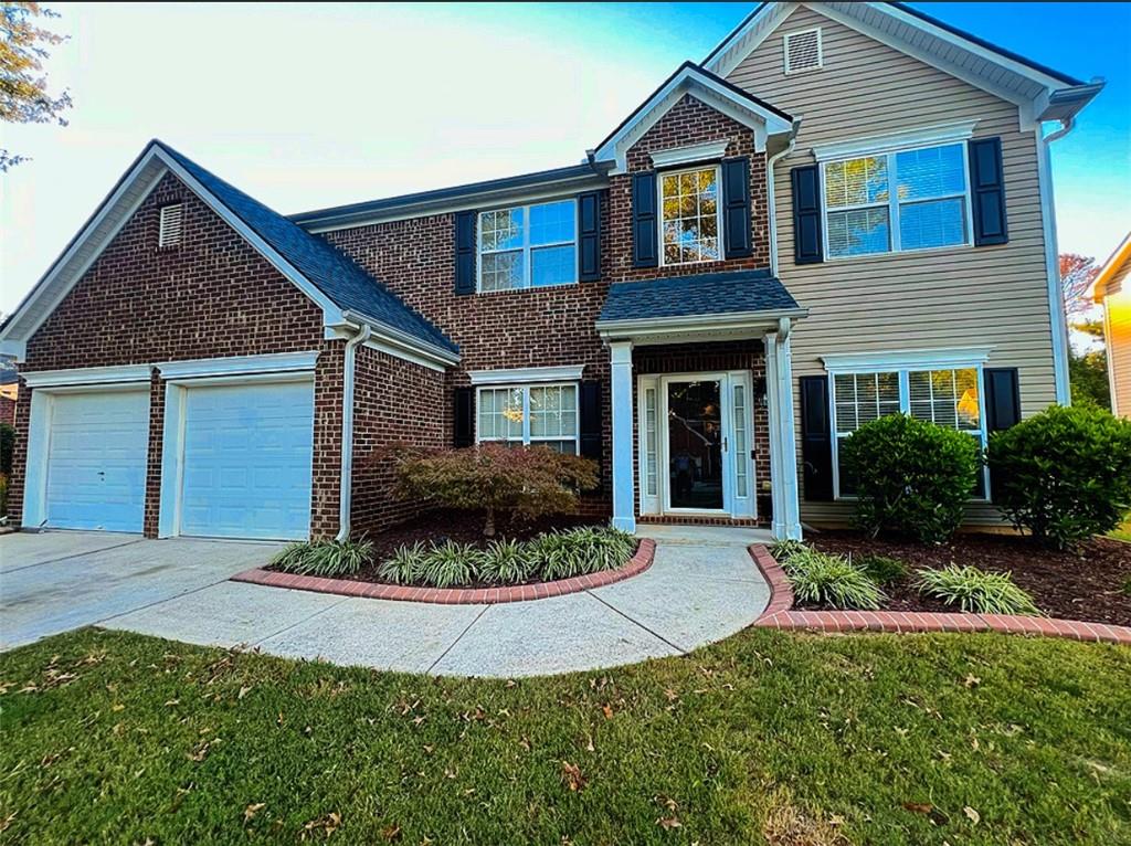 a front view of a house with a yard and garage