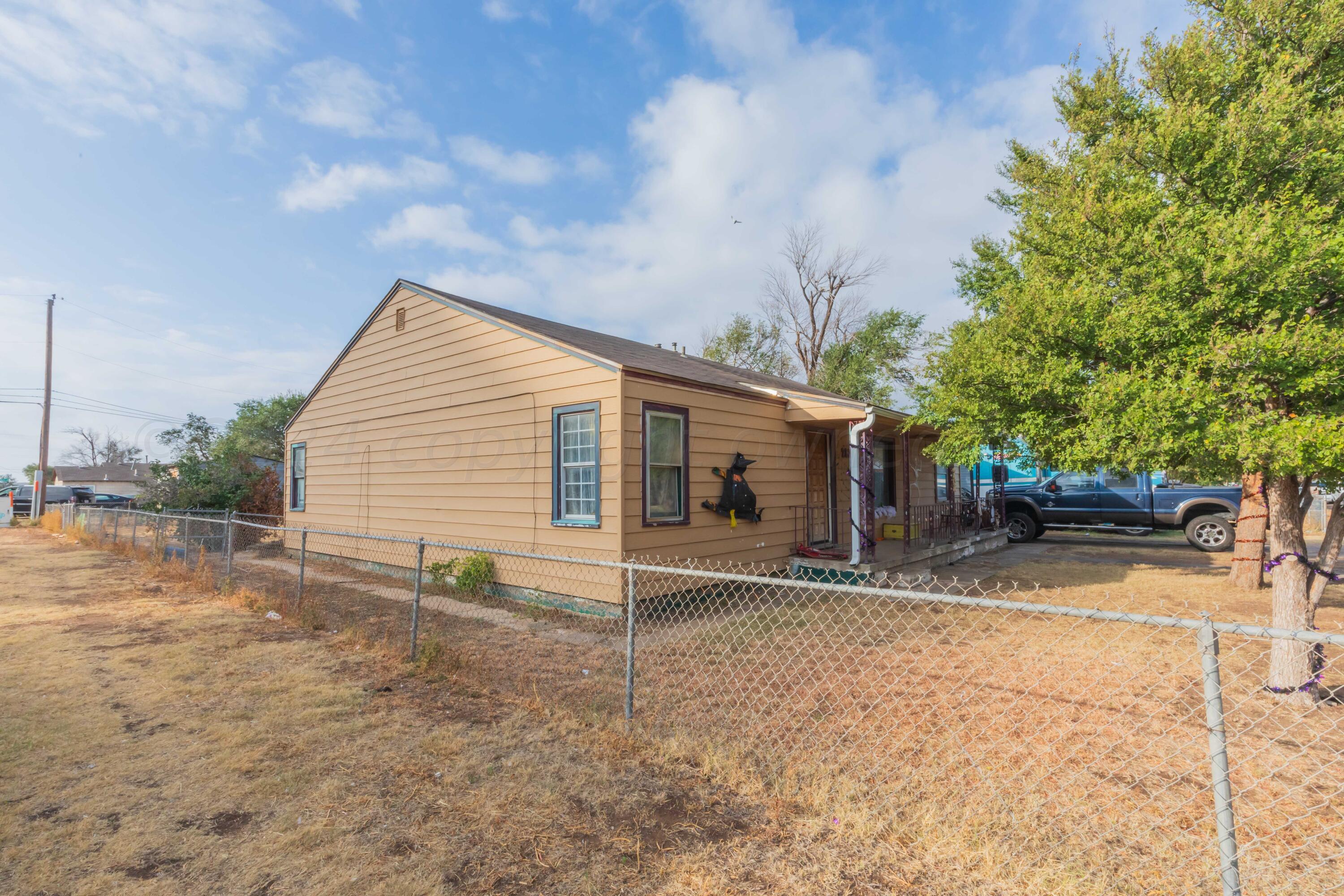 a view of house with backyard and trees in the background