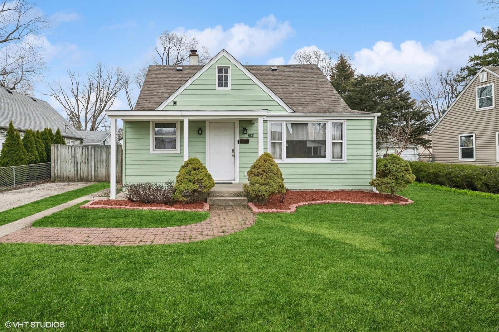 a front view of a house with a garden and plants