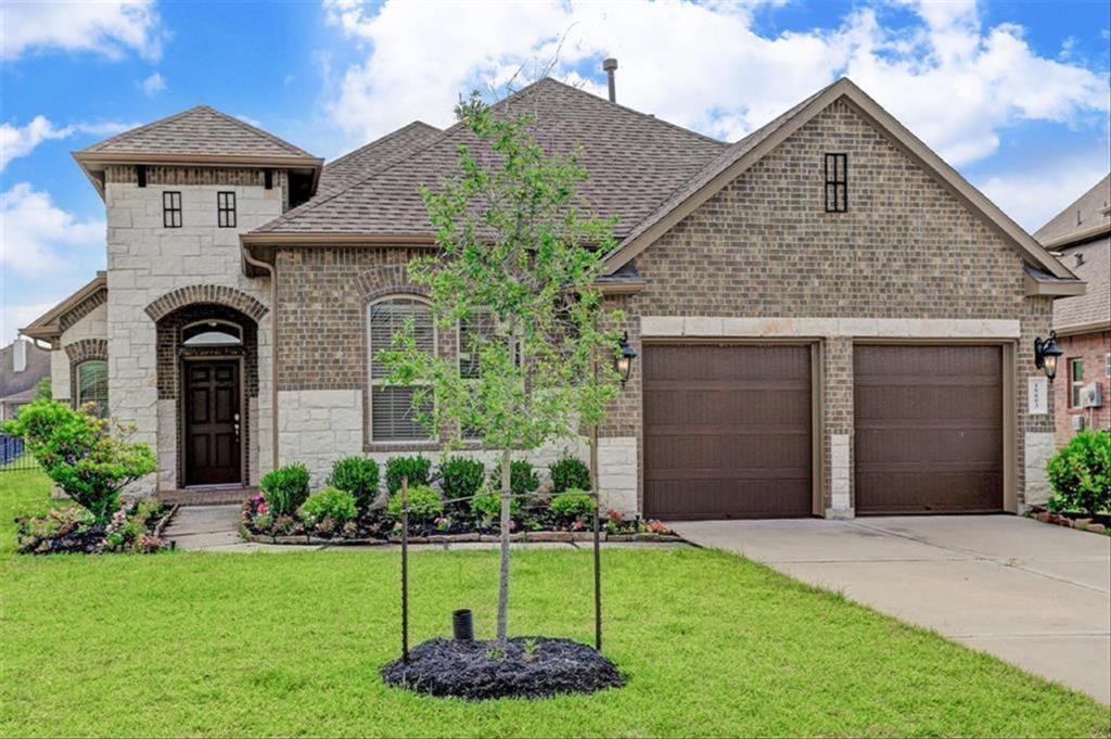 a front view of a house with a yard and garage