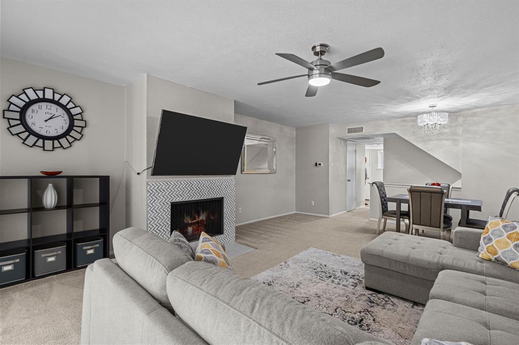 a living room with furniture a fireplace and a flat screen tv