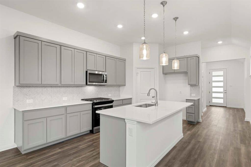 a kitchen with a sink stove and cabinets