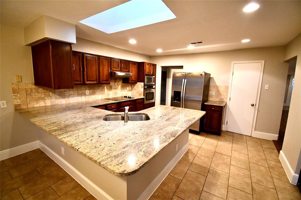 a kitchen with a sink a counter top space cabinets and stainless steel appliances