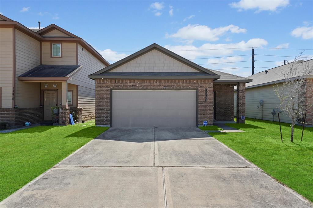 a front view of a house with a yard and garage