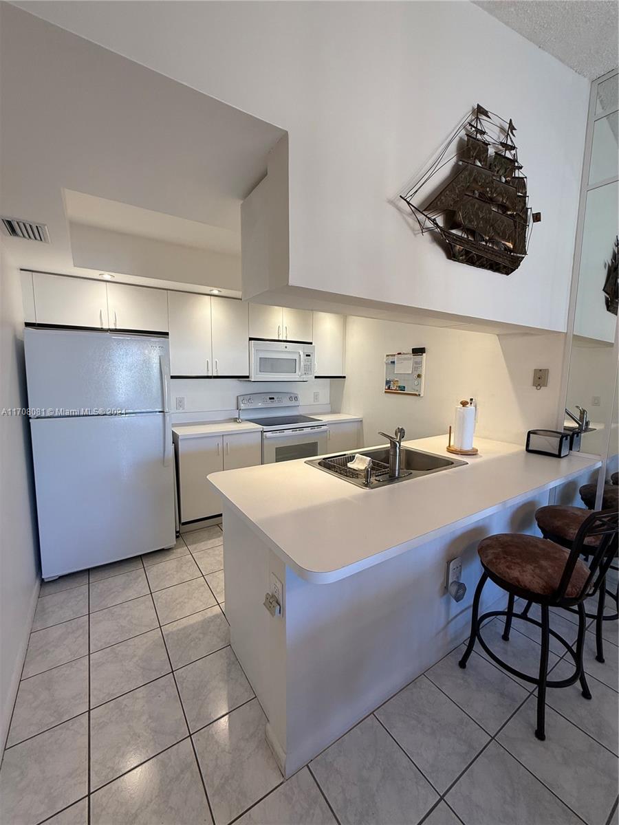 a kitchen with stainless steel appliances a sink a table and chairs in it