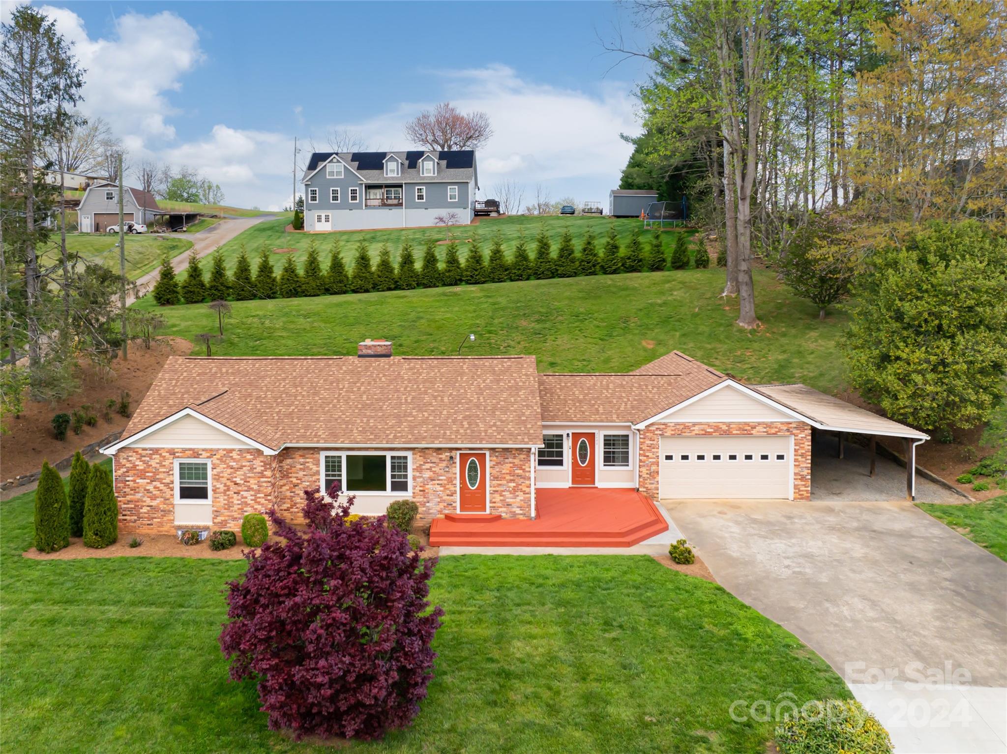 a aerial view of a house next to a big yard and large trees