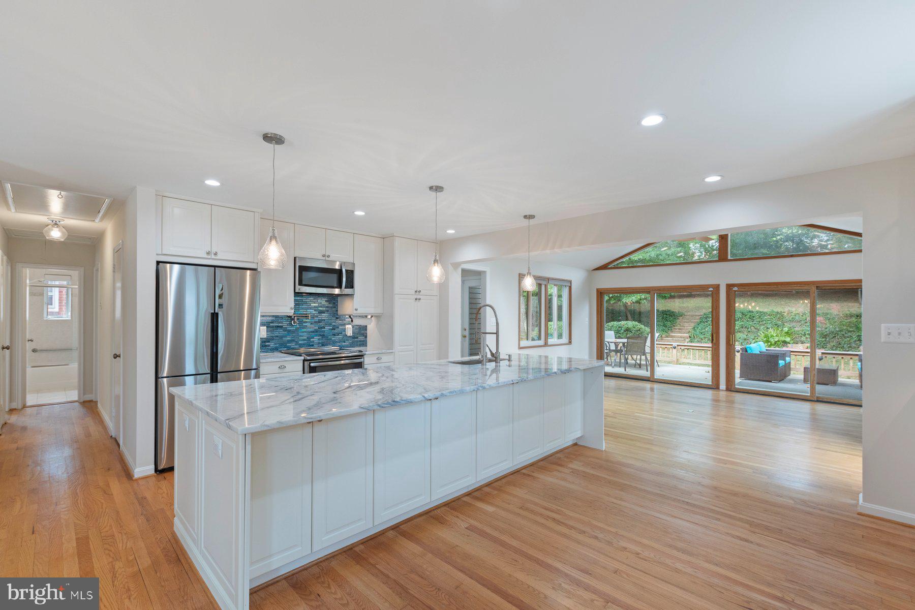 a large kitchen with large windows and wooden floor