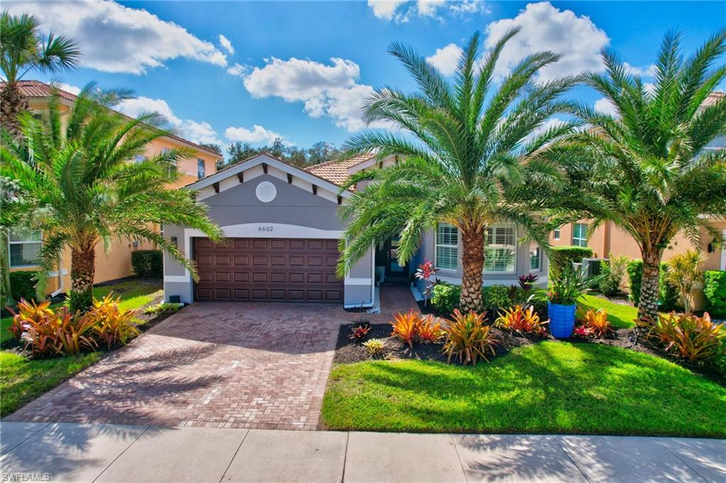 a front view of a house with a yard and a garden