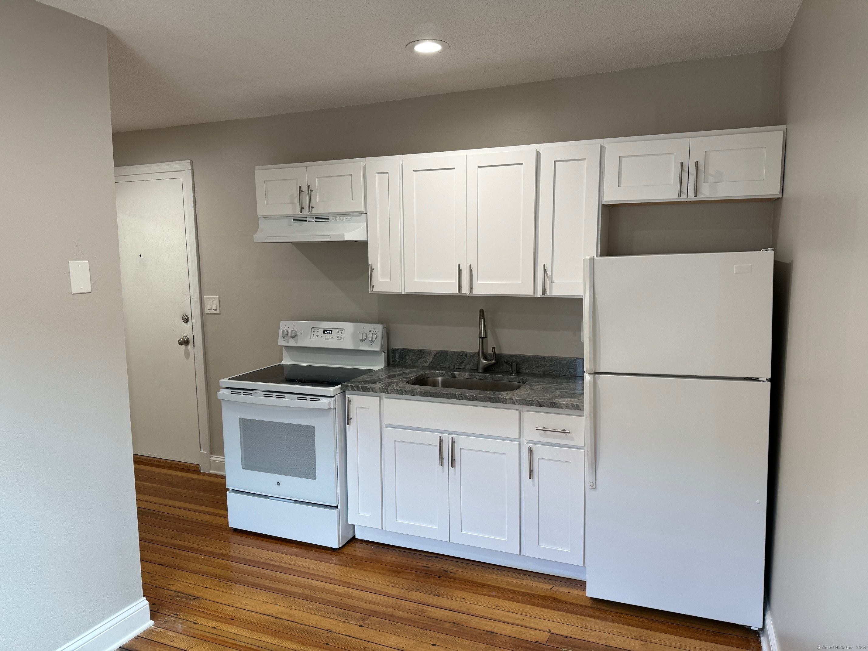 a kitchen with white cabinets and white appliances