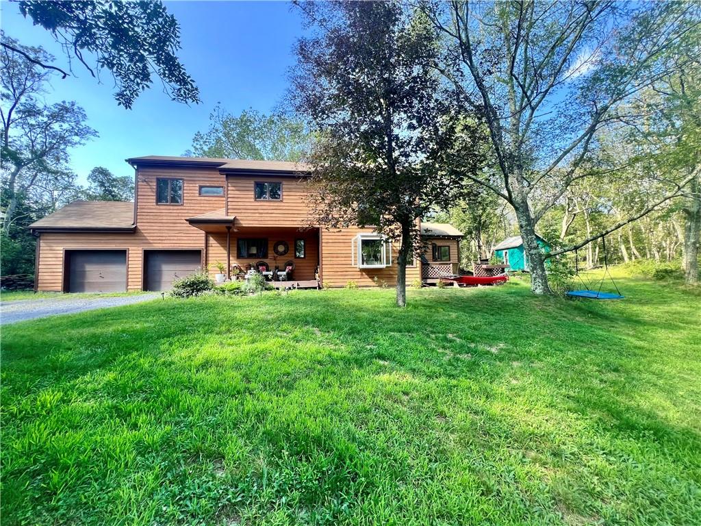 a view of a house with a big yard and large trees