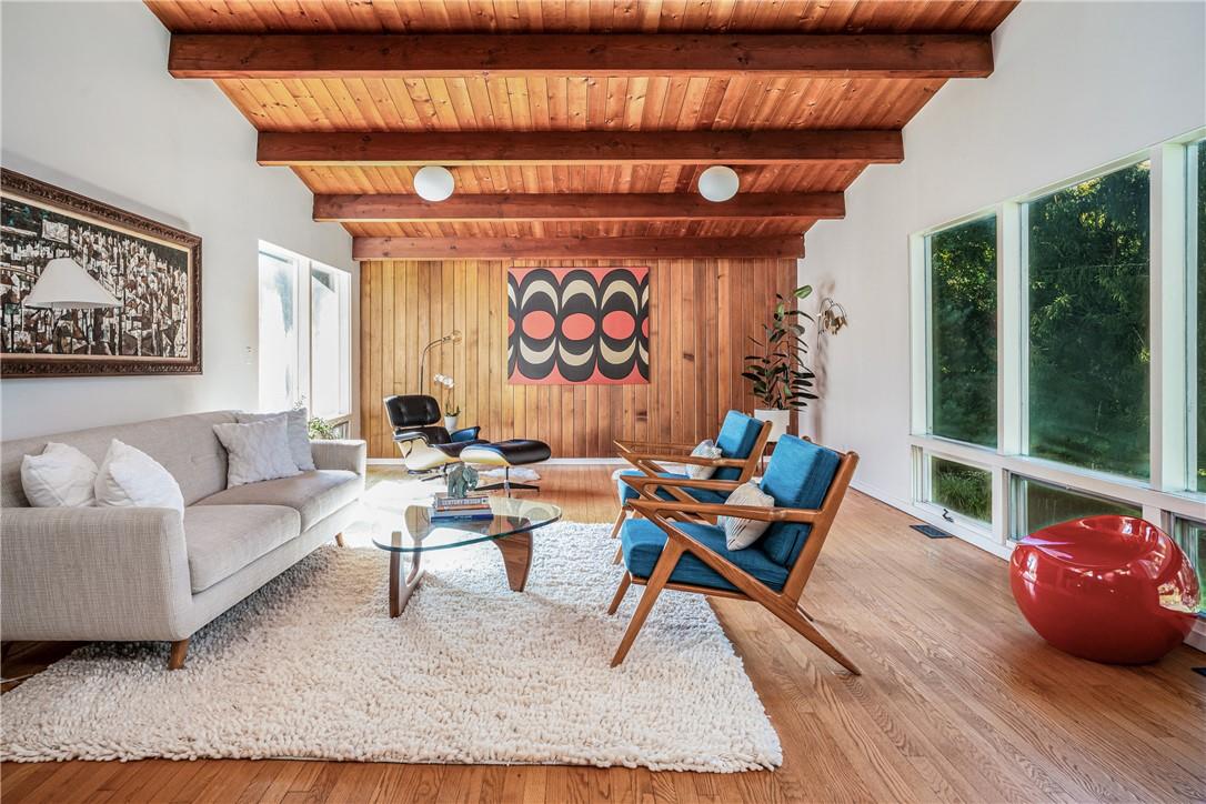 Stunning living room with wood wall and windows overlooking yard