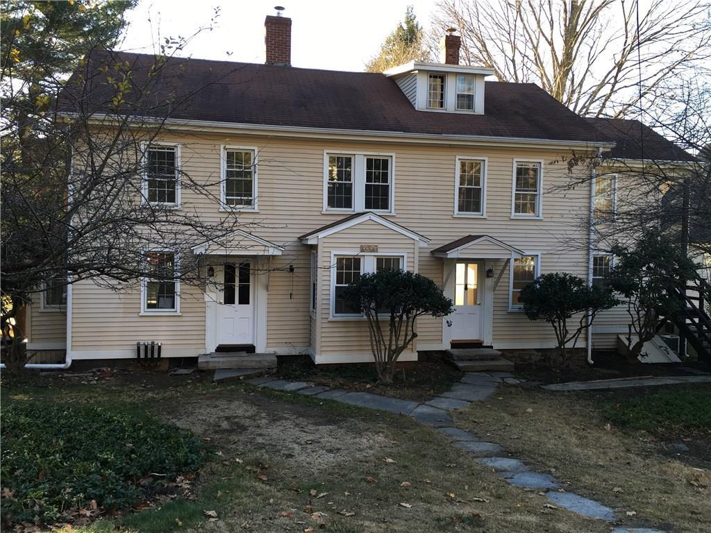 a view of a white house with a yard and large tree