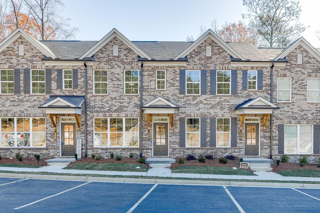 front view of a brick house with a large windows and a yard