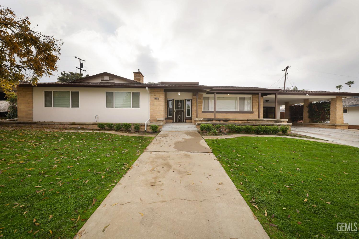 a front view of a house with a garden and yard