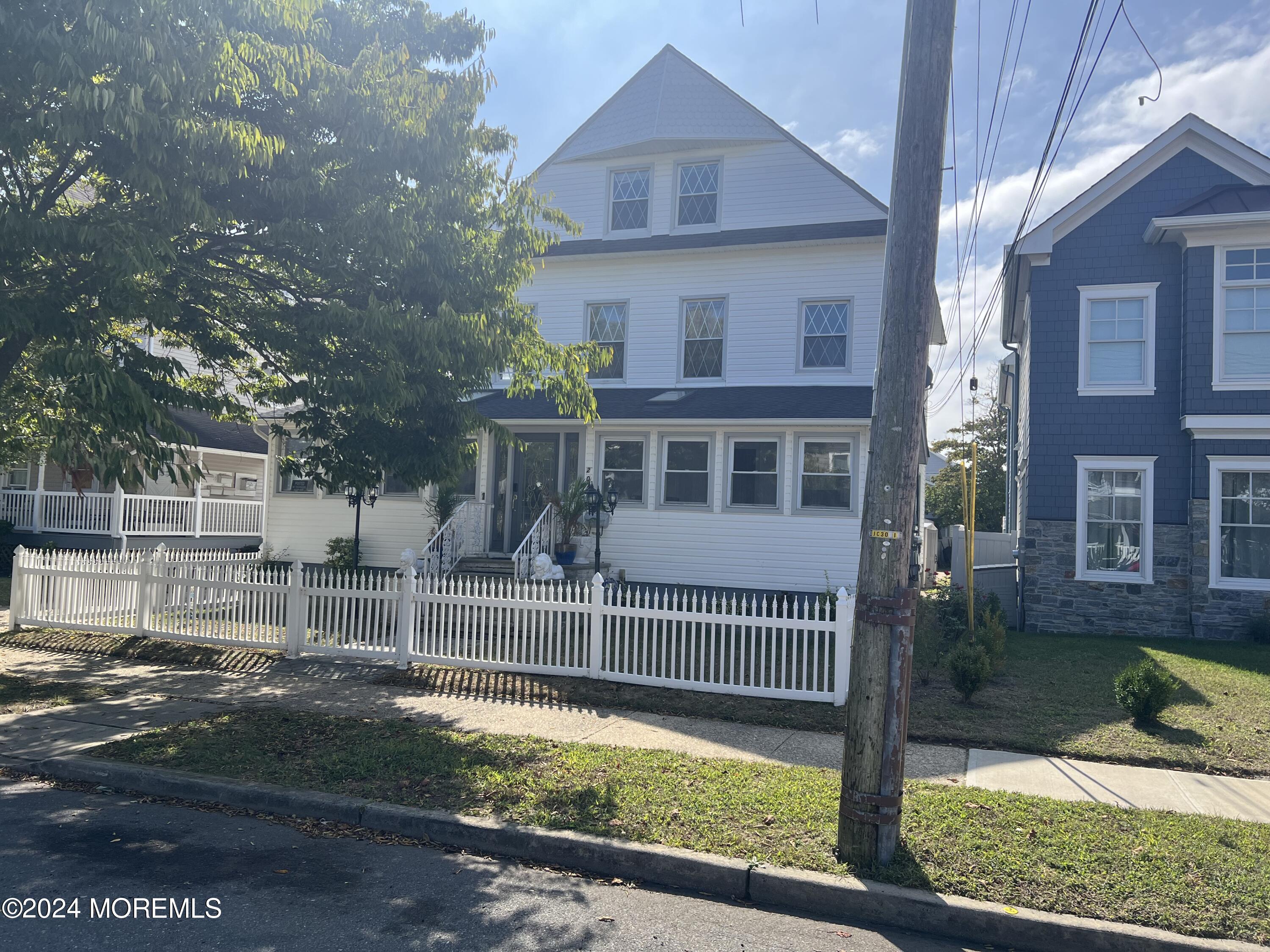 a view of a house with a small yard and wooden fence