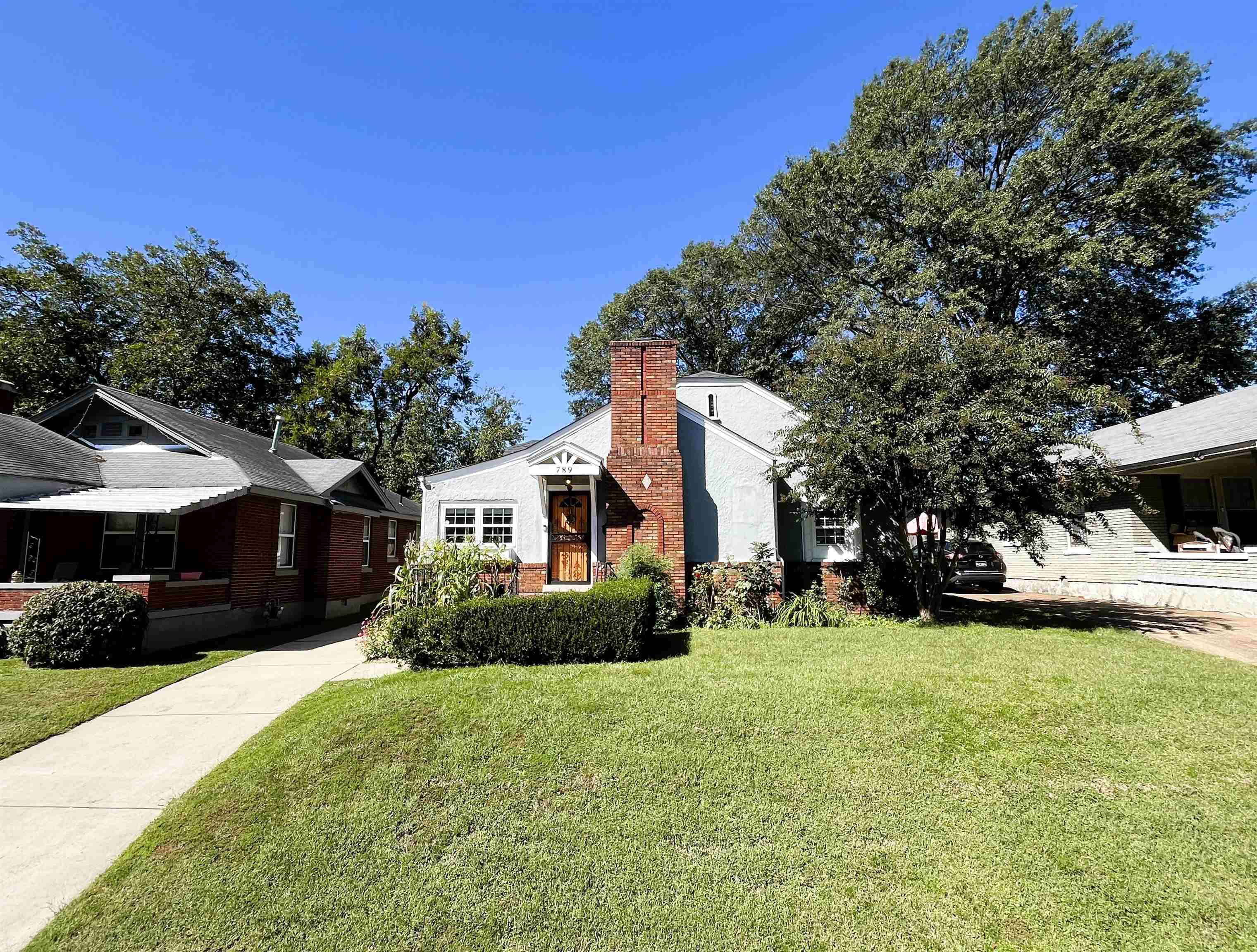 a front view of a house with a yard and trees