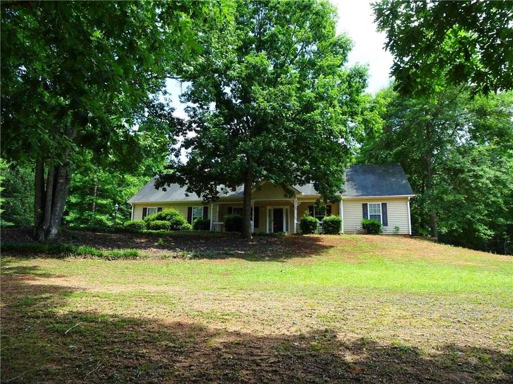 a front view of a house with yard and green space