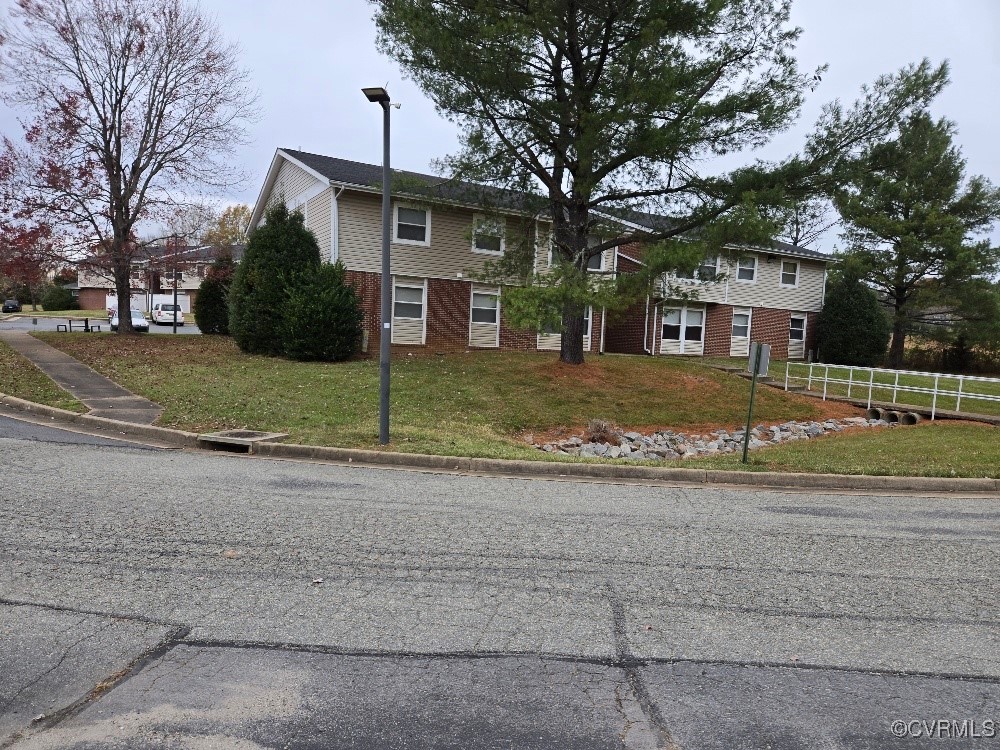 a view of a house with a yard and large tree