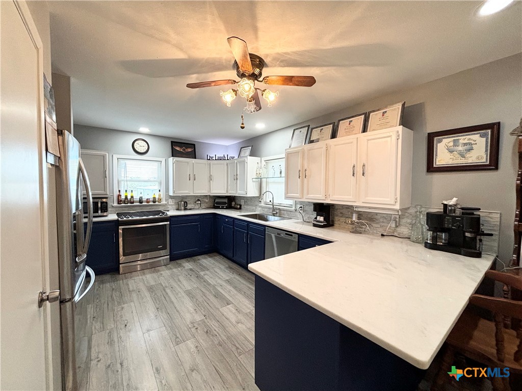 a kitchen with a refrigerator a sink dishwasher with a dining table and chairs