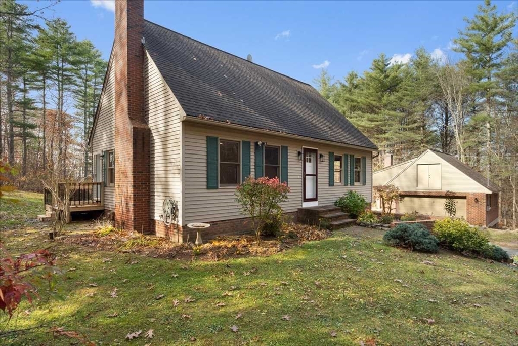 a view of a house with backyard and sitting area