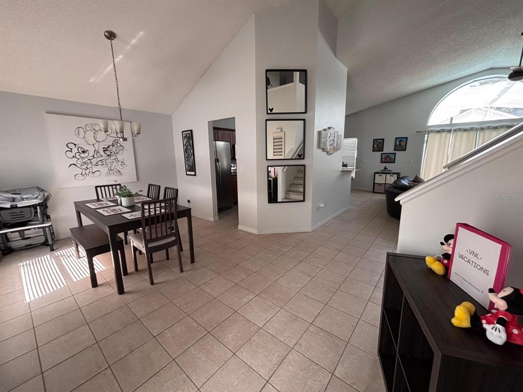 a living room with furniture a dining table and a chandelier