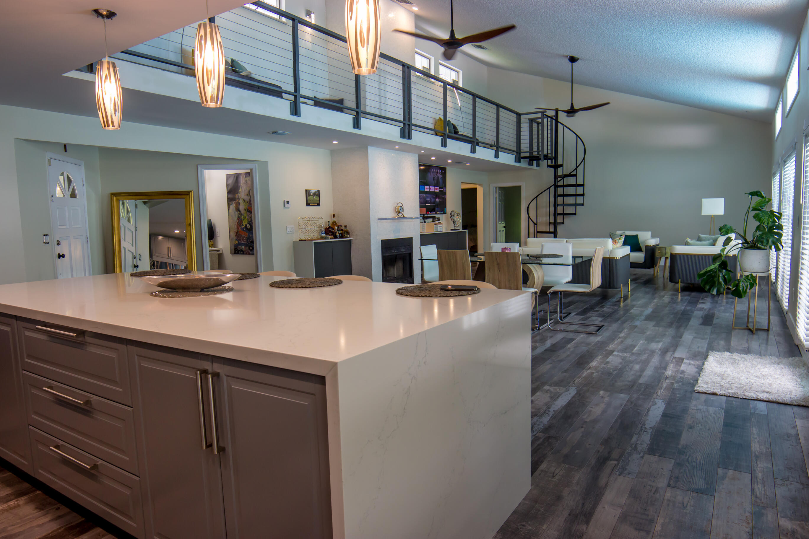 a kitchen with a sink dishwasher a dining table and chairs with wooden floor