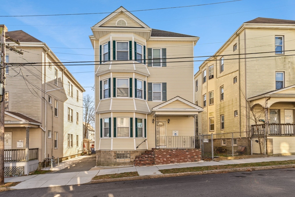 a front view of a residential apartment building with a yard