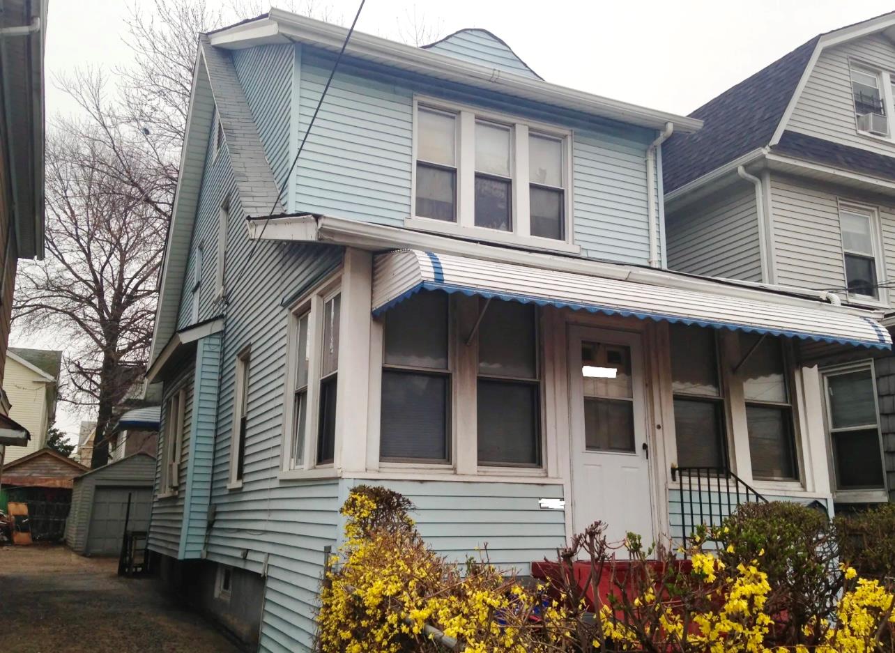 View of front of property featuring an outdoor structure and a garage