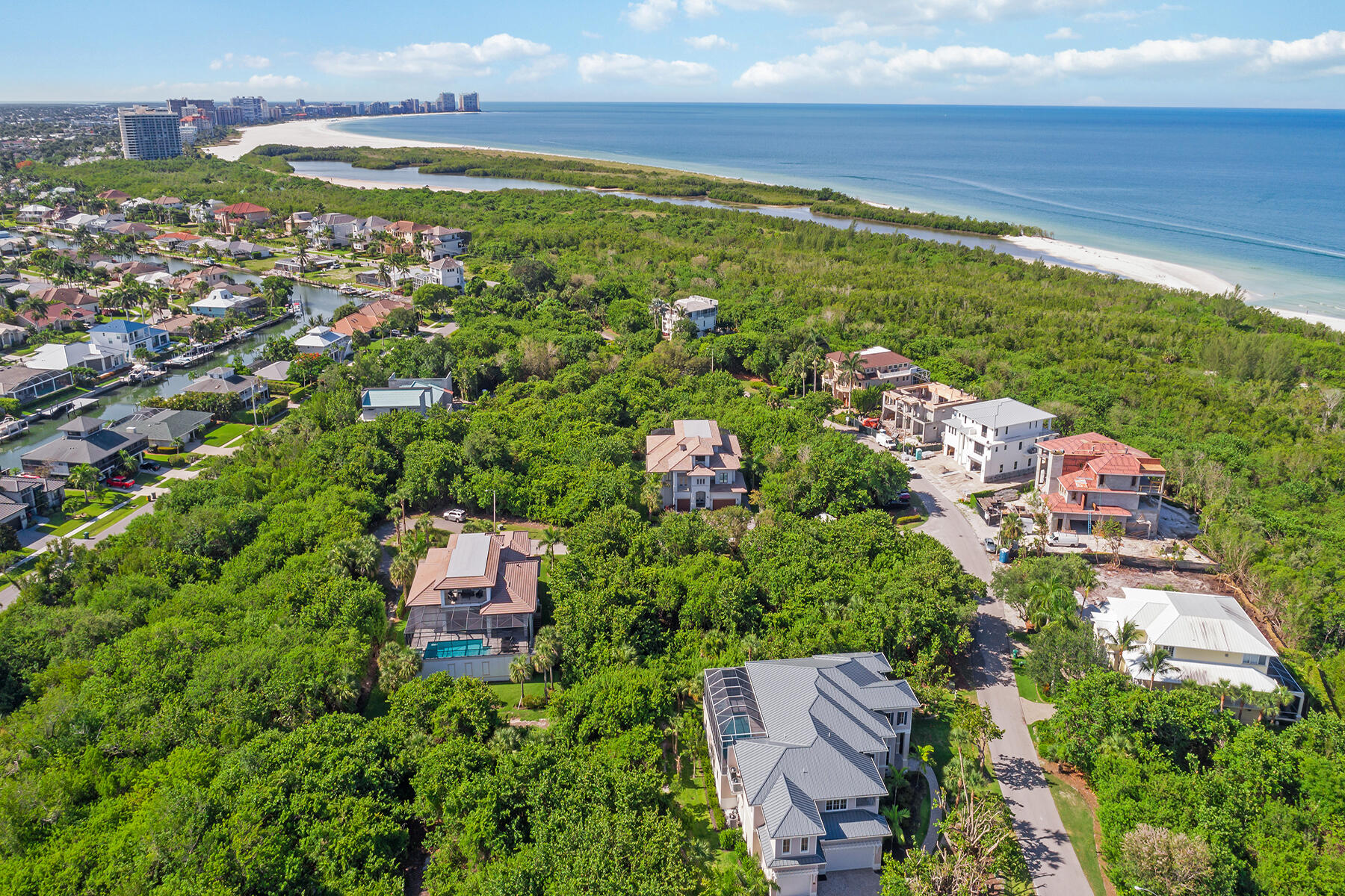 an aerial view of residential houses with outdoor space and trees all around