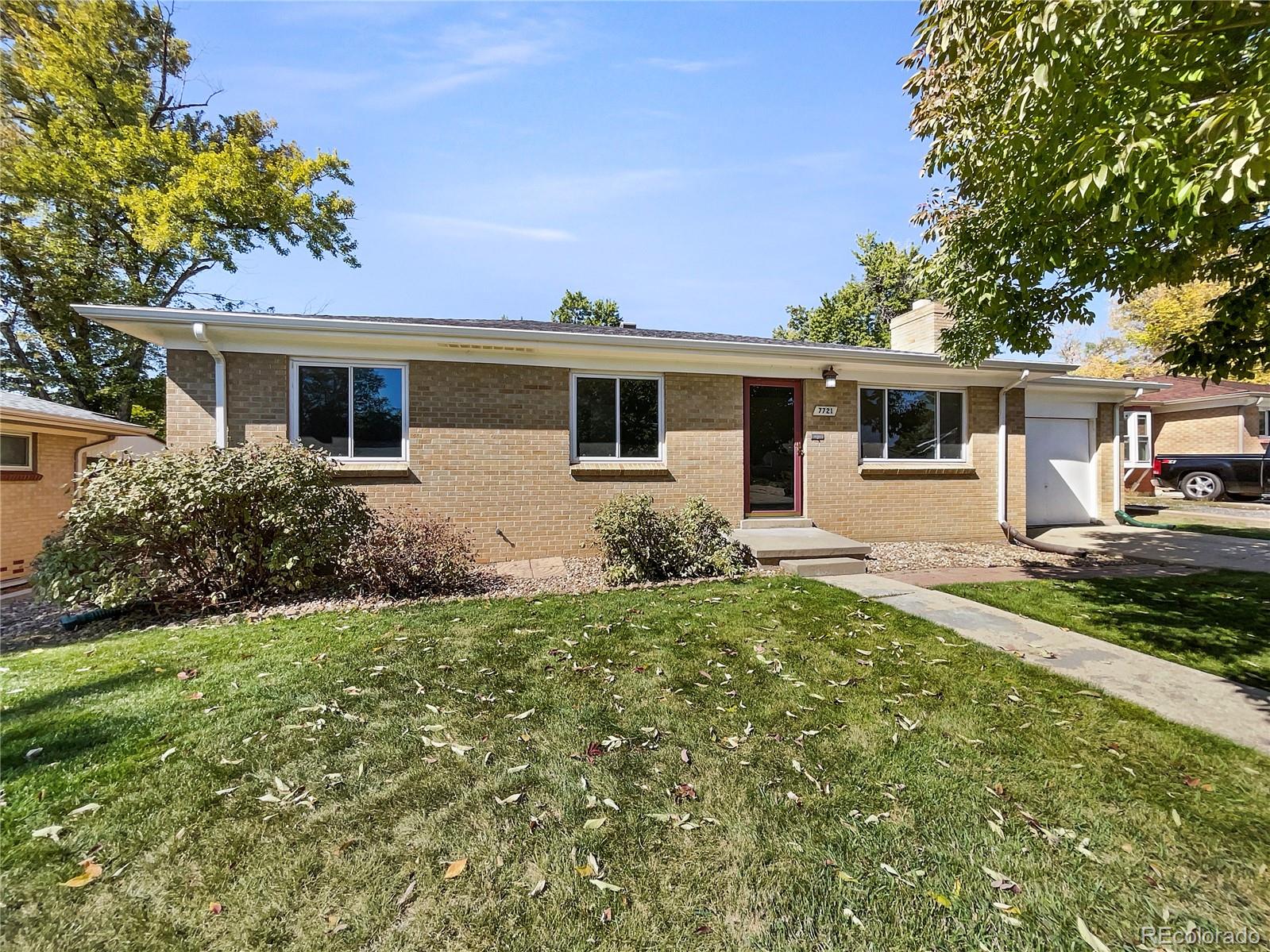 a front view of house with yard and trees in the background